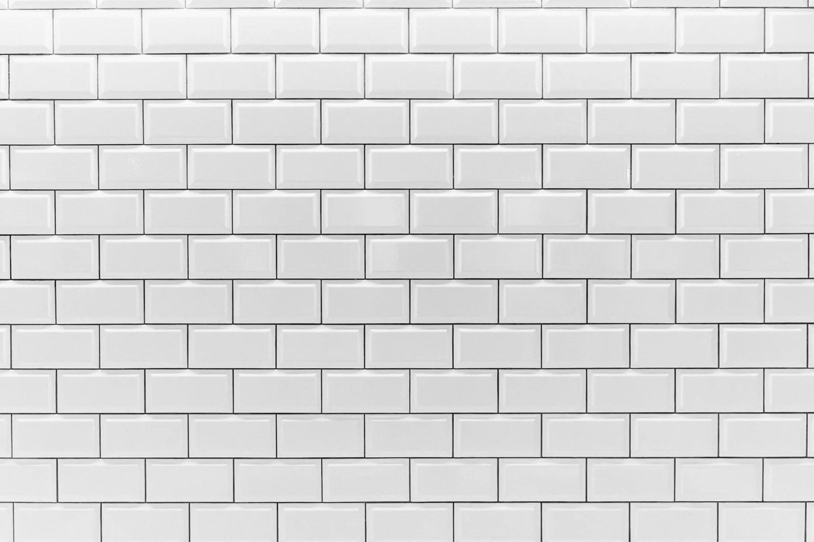 Clean white subway tile wall in a uniform brick pattern